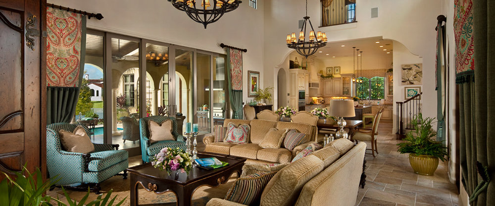 living room with high ceilings, light beige couches and dark brown railing and tables